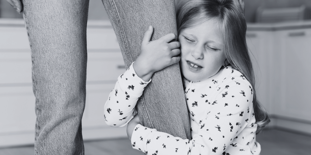Little girl holding the parent on one leg.