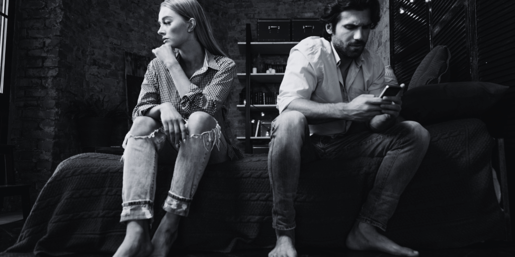 couple sitting side by side ignoring each other