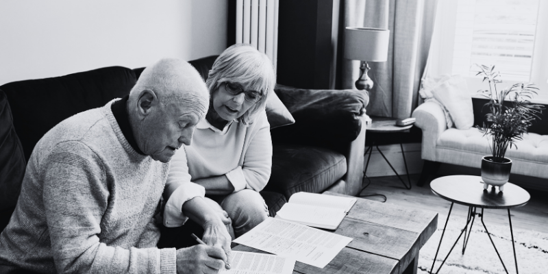 elderly man signing what looks like a divorce paper