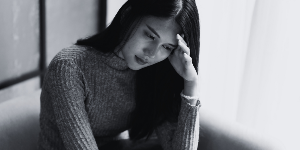 A woman sitting, looking sad and worried. Divorce Regret: What Clients Wish They Knew Before Filing