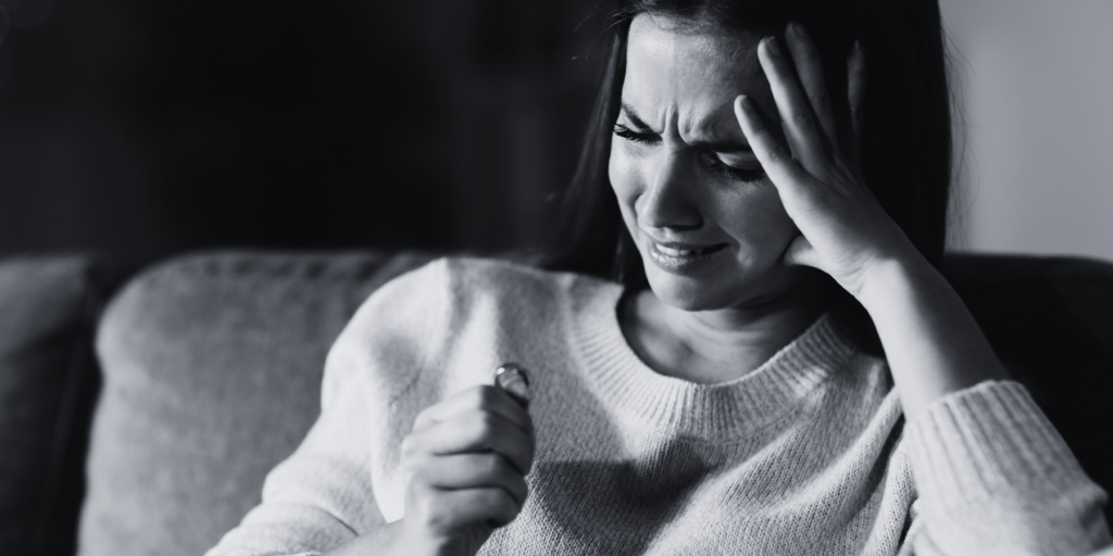 A woman holding a ring and crying. Government or legal professional guides on drafting a South African parenting plan.