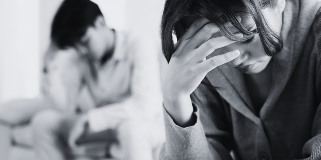 a man and a woman bent down sad. Government or legal professional guides on drafting a South African parenting plan.
