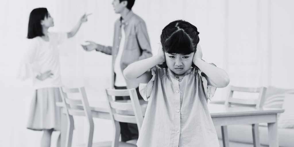 A child blocking her ear to avoid listening to her parents quarrel. Understanding Child Custody in South African Divorce Cases