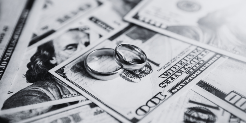 two rings on top of some dollar bills
