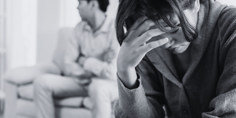 A couple sitting apart and looking sad. 